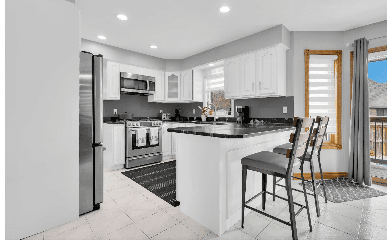 White kitchen with black granite counters and breakfast island