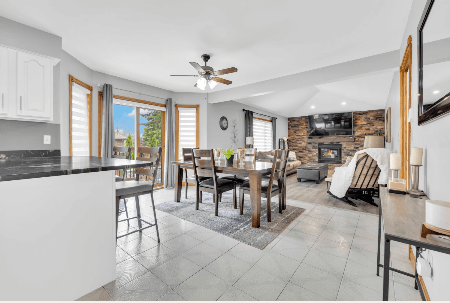 Open-plan kitchen, dining and living area with a stone fireplace