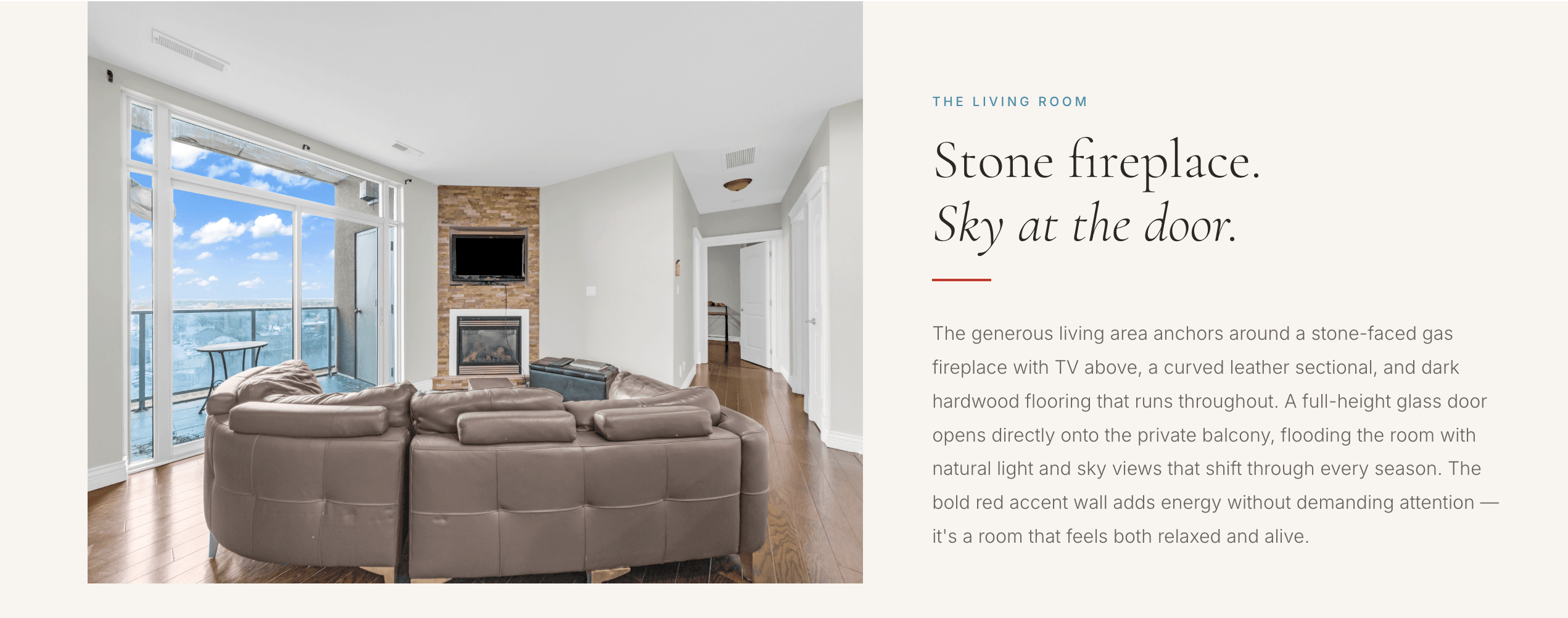 Condo living room with a stone fireplace and full-height glass onto a balcony